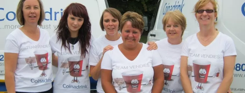 A group of women standing in front of a van.
