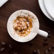 A cup of coffee with whipped cream and chocolate chips.
