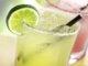 Two lime margaritas on a table.