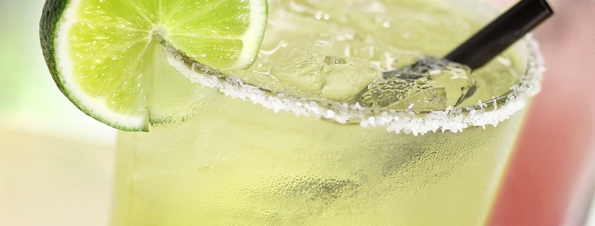 Two lime margaritas on a table.