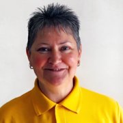 3030 A woman in a yellow polo shirt smiling.