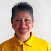 3030 A woman in a yellow polo shirt smiling.