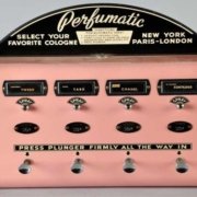 Perfume Vending Machine A pink machine with four buttons on it that dispenses perfume.