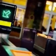 subway_station A group of people doing squats in front of a ticket machine.