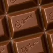 A close up of a chocolate bar with the word Cadbury written on it, reminiscent of the 'drumming gorilla' TV commercial.