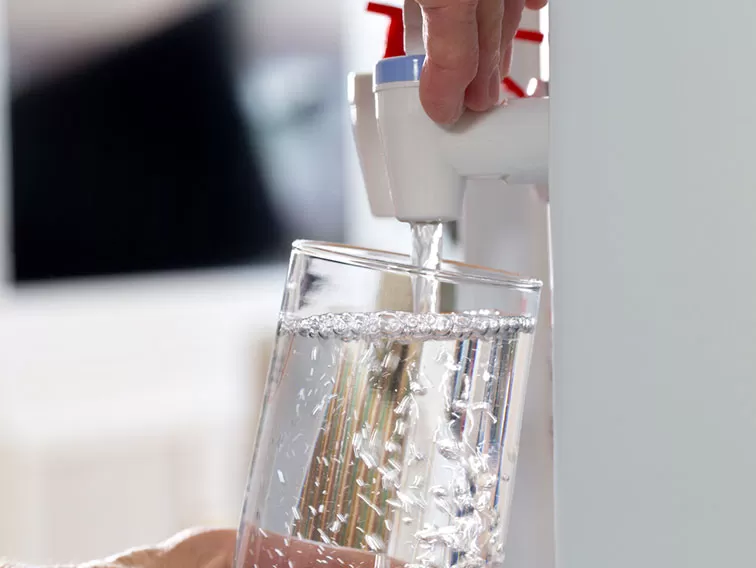 A person pouring water into a glass.