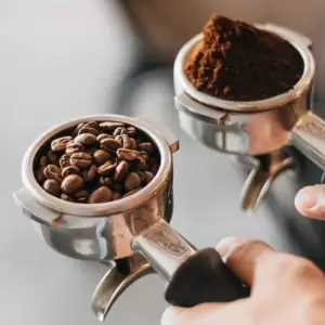 A person using a Gaggia MD64 coffee grinder.