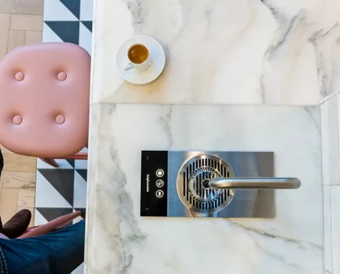 Gallery-2 A man sitting on a marble counter with a cup of coffee.