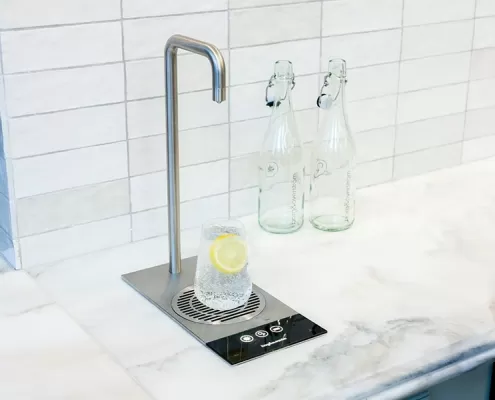 Gallery-6 A bottle of water is sitting on a counter top.