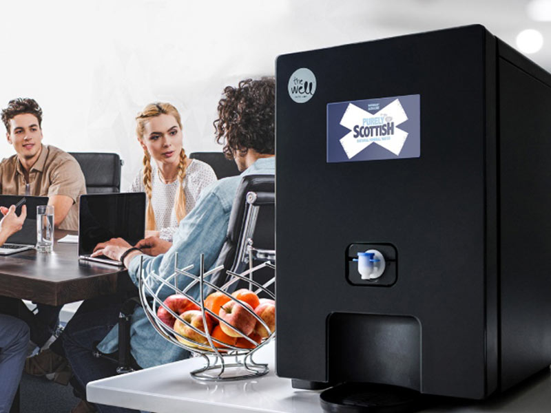 boxed-water-coolers-supplier A group of people sitting around a coffee machine.