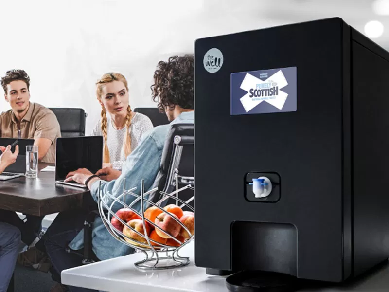 boxed-water-coolers-supplier A group of people sitting around a coffee machine.