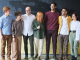 A group of people standing in front of a chalkboard.
