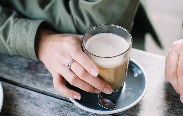 Vitro-X1-MIA-tabletop-coffee-machine-milk Two hands holding a cup of coffee.