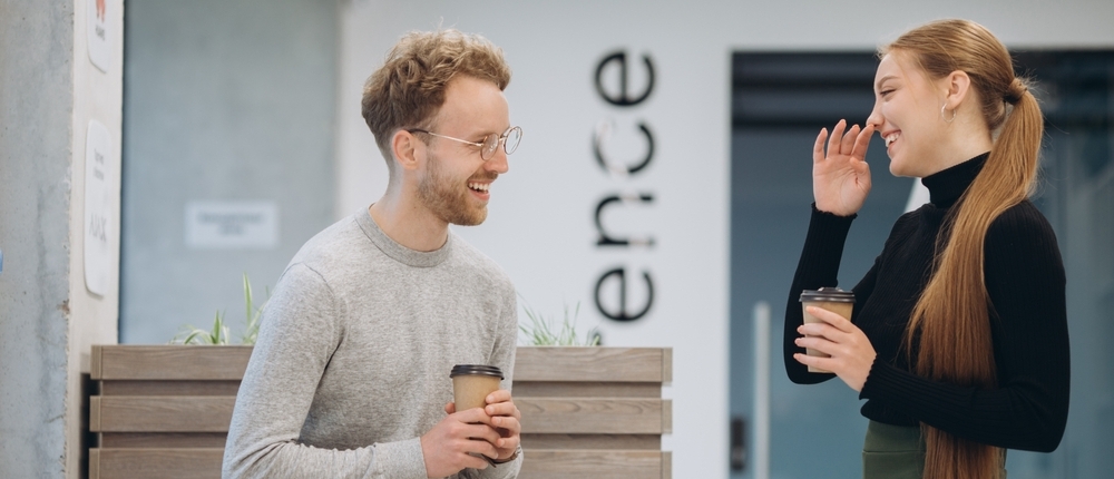 Happy staff taking a coffee break in the corridor