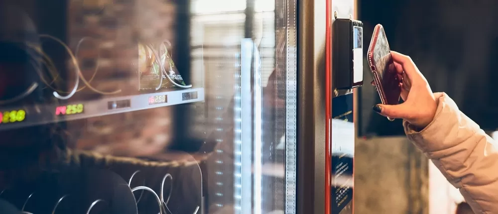 Woman paying contactless at the vending machine