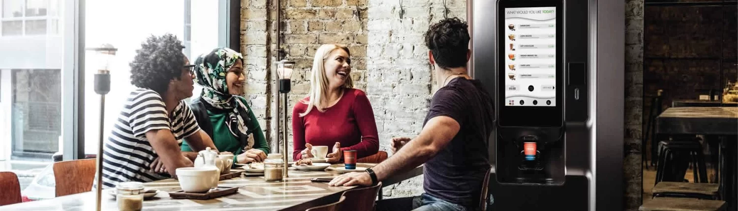 Staff enjoying a hot drink from a hot beverage vending machine.